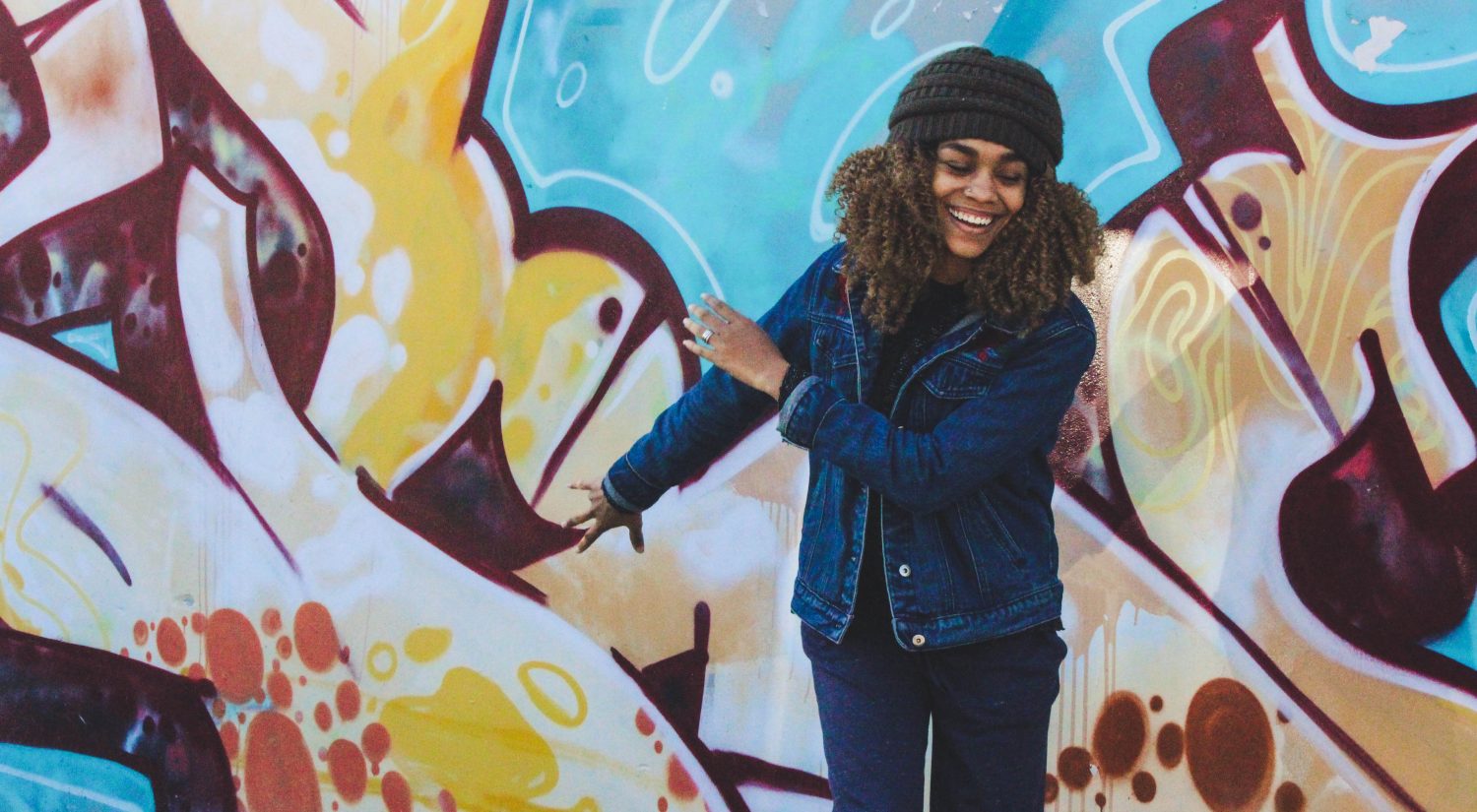 Happy women smiling against painted wall