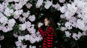 Young girl smelling flowers in garden