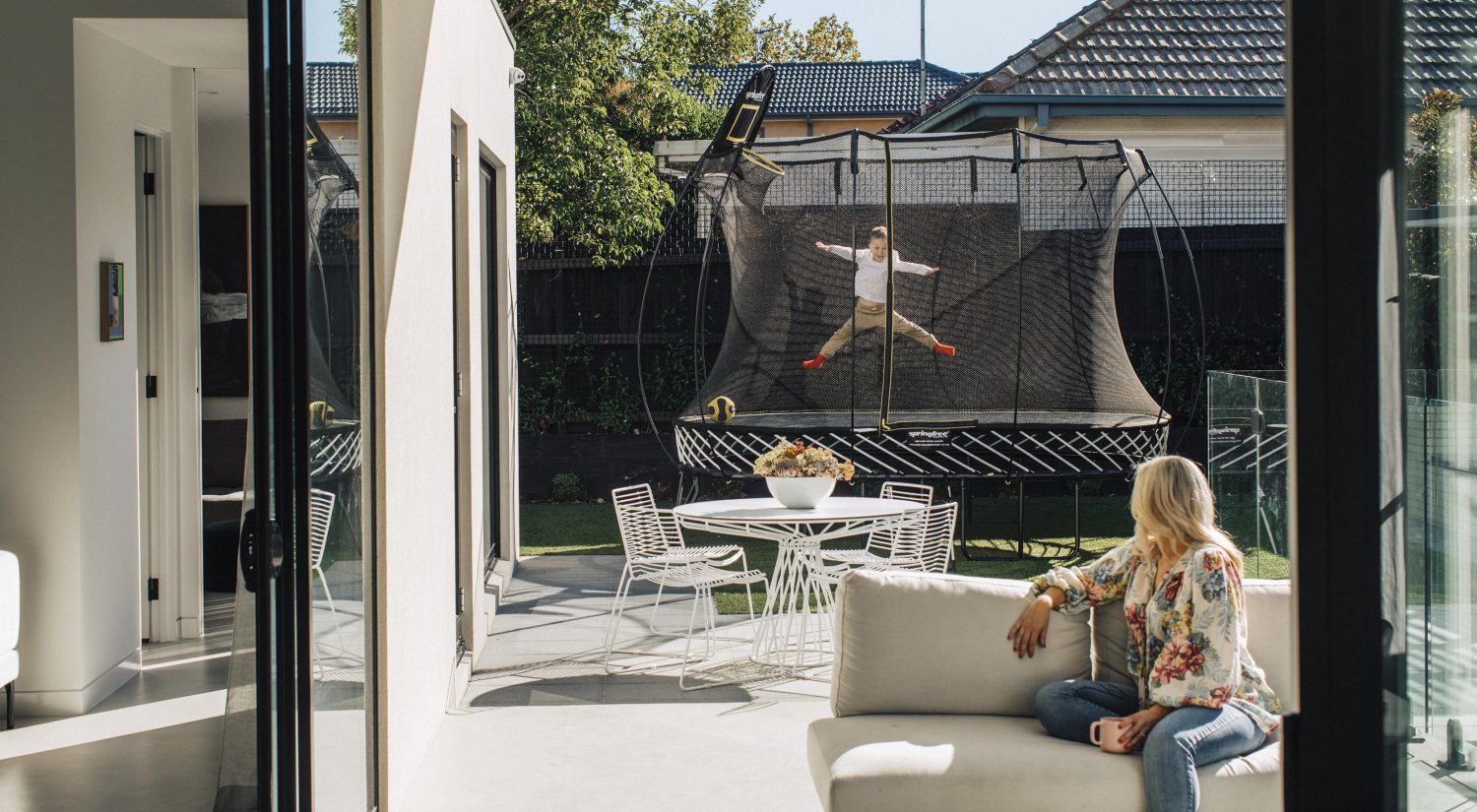 Springfree trampoline set up in backyard with outdoor setting