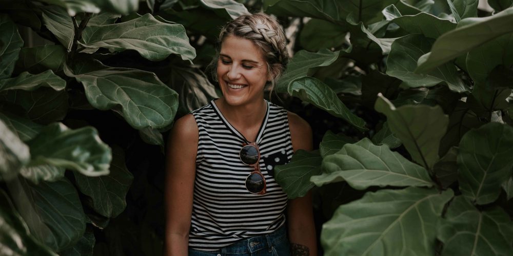 Woman happy smiling standing against greenery