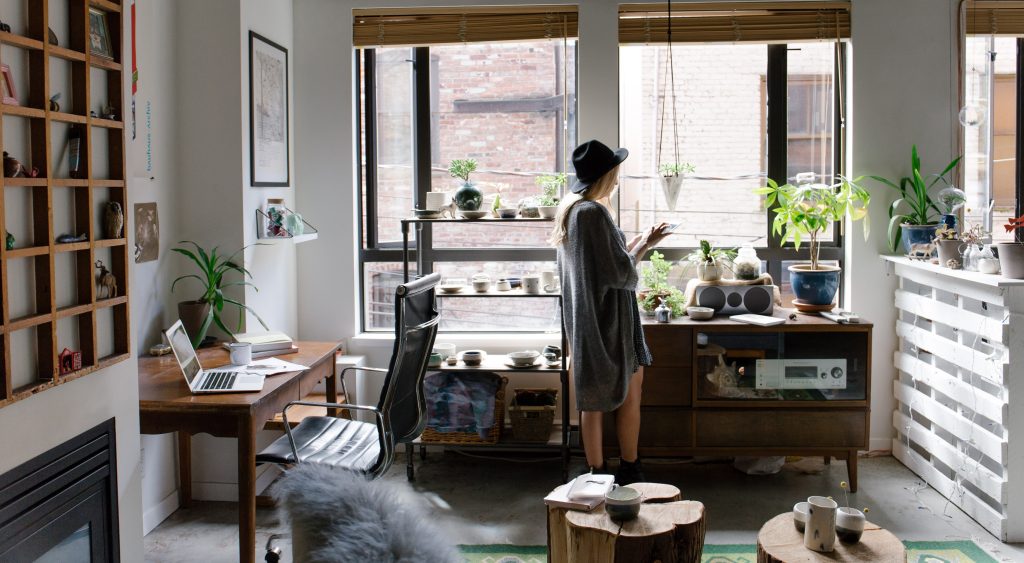 Woman standing in her stylish home office with plants