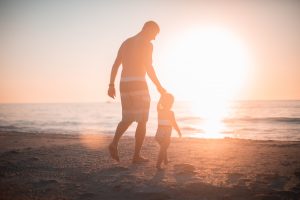 Dad and baby walking on sand at beach