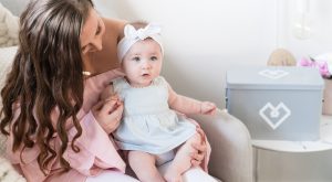 Mum holding baby girl with Tiny Hearts first aid box