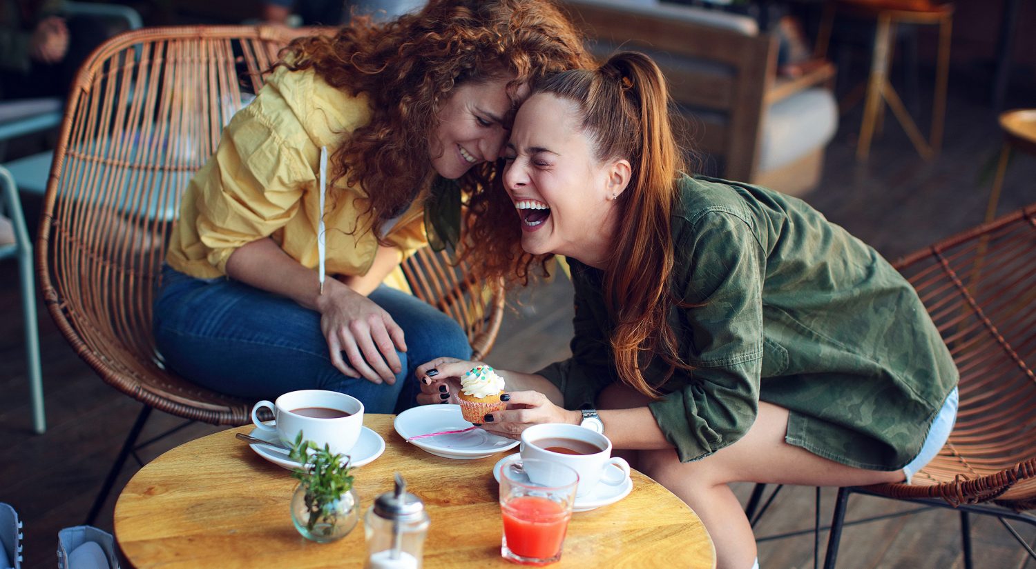 Two women laughing at coffee shop