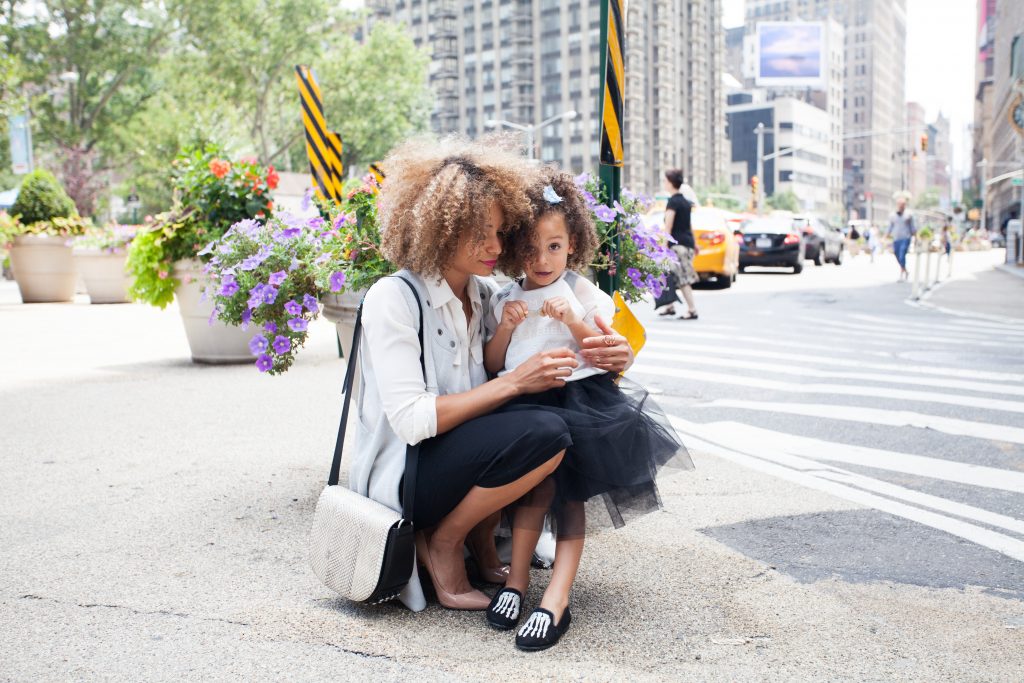 Working mum standing on street with daughter