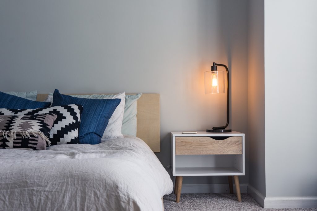 Bed with bedside table and lamp