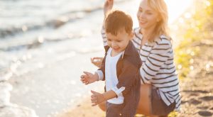 Carer playing with child on beach