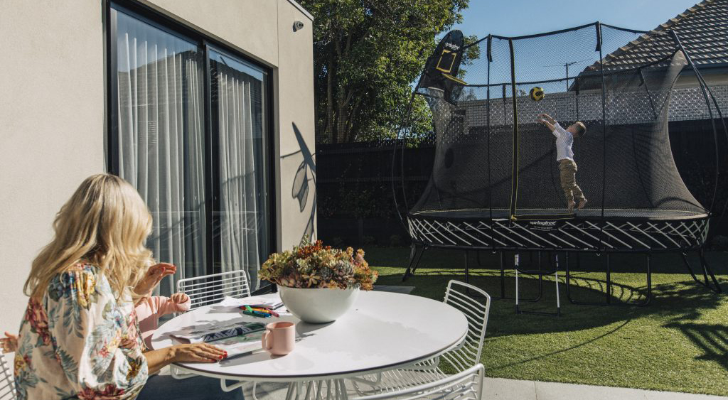 Mum watching over boy on Springfree Trampoline
