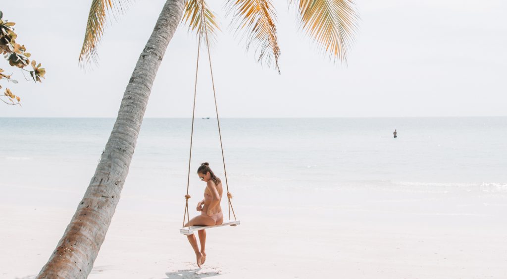 Woman on swing on beach