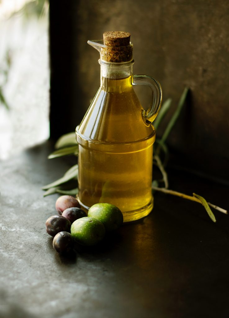 Glass jar of olive oil on kitchen bench