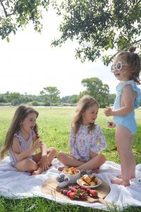Willow Swim kids eating at picnic wearing swimsuits