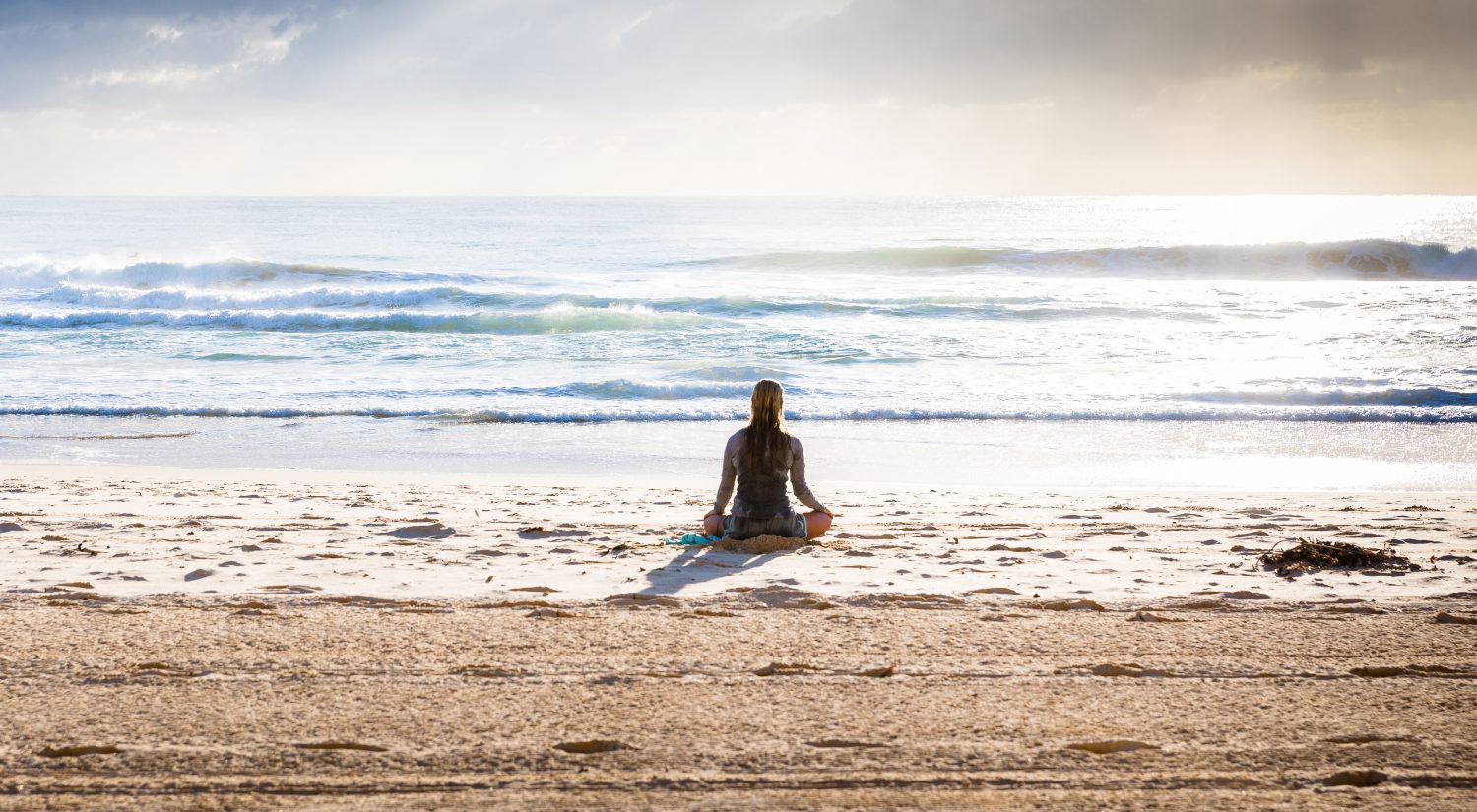 Women doing yoga meditation on beach