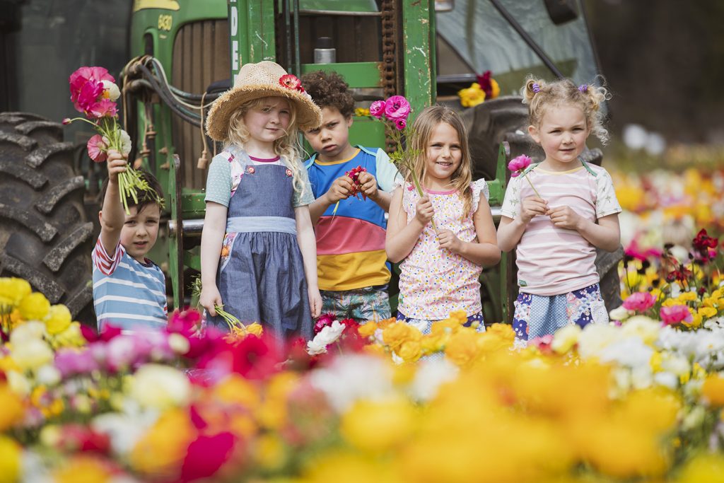 Oishi-m kids standing in field of flowers