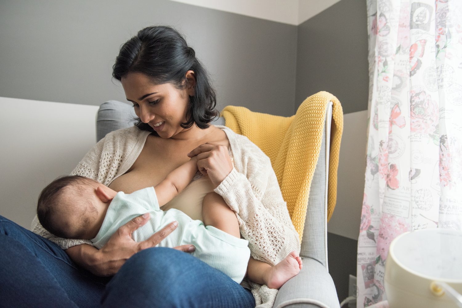 mother breastfeeding her baby in a nursery