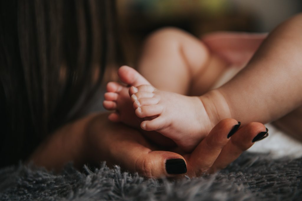 Mum holding newborn baby feet