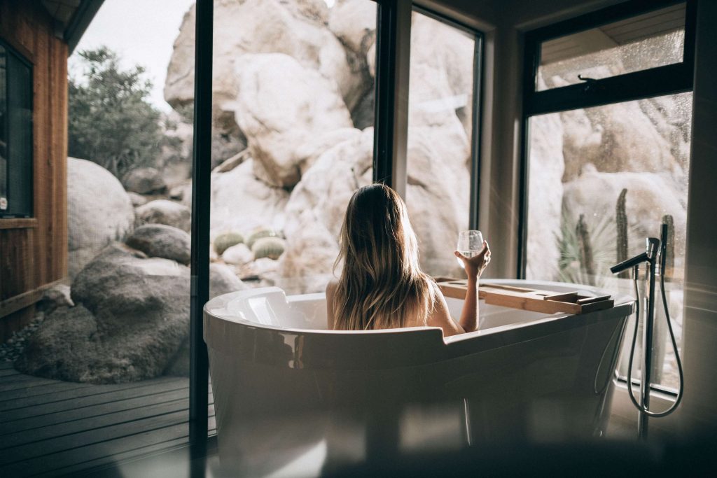 woman in bath relaxing with a drink